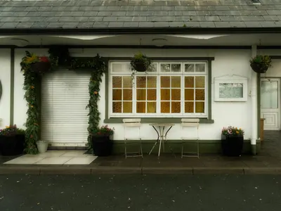 Charming outdoor café with floral decor and vintage furniture, perfect for a pea 4k aesthetic wallpaper