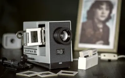 Close-up of a retro slide projector with blurred photo frame in the background. 4k aesthetic wallpaper