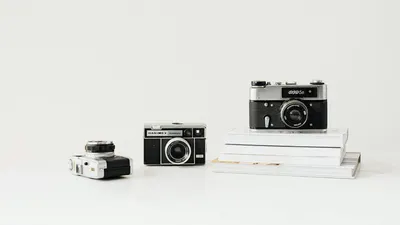 Three vintage cameras displayed on a white background, emphasizing nostalgia and 4k aesthetic wallpaper