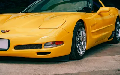 A vibrant yellow sports car parked on a sunny day, showcasing luxury and perform 4k cars wallpaper