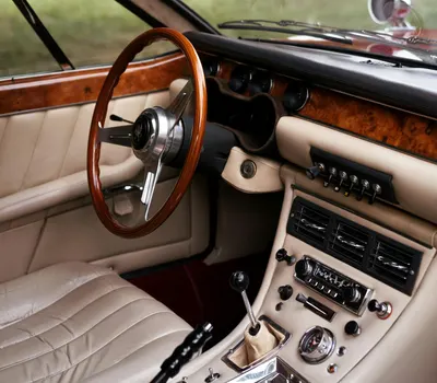 Close-up of a vintage car interior featuring wooden trim, leather upholstery, an 4k cars wallpaper