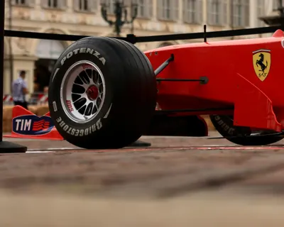 Close-up shot of a red Formula 1 racing car with visible brand logos and Bridges 4k cars wallpaper