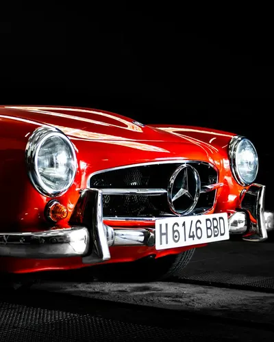 Elegant red Mercedes 300SL classic car with a shiny emblem. 4k cars wallpaper
