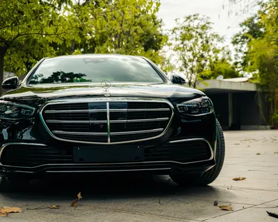 Front view of a luxurious black Mercedes Benz parked in a serene outdoor setting 4k cars wallpaper