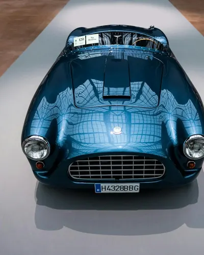 Front view of a polished blue vintage car on display indoors, showcasing classic 4k cars wallpaper