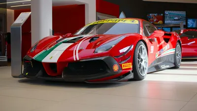 Showroom display of a red Ferrari sports car with racing decals and vibrant desi 4k cars wallpaper