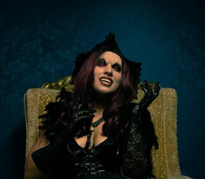 A dramatic portrait of a woman in vampire costume with gothic makeup and attire. 4k dark wallpaper