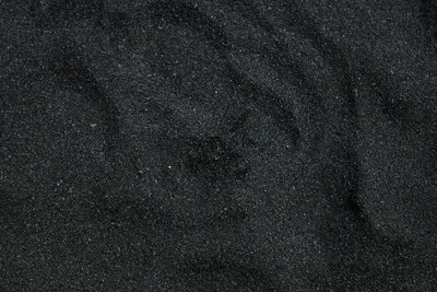 Close-up of black sand texture from Waimea Beach in Hawaii. Ideal for background 4k dark wallpaper