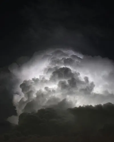 Powerful lightning illuminates dark storm clouds at night, creating a dramatic a 4k dark wallpaper