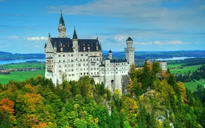 A scenic view of Neuschwanstein Castle surrounded by vibrant autumn foliage, set 4k fantasy wallpaper