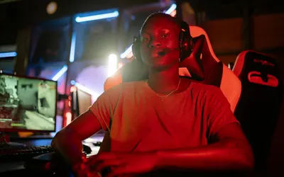 A focused gamer wearing a headset in a neon-lit room, ready for action. 4k gaming wallpaper