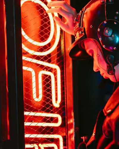 A woman in cyberpunk attire stands by vibrant neon lights, creating a futuristic 4k gaming wallpaper
