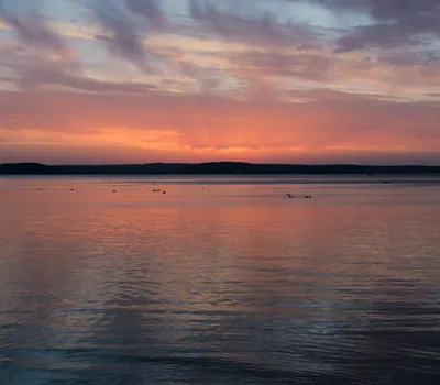 A stunning sunset with pink and purple hues reflecting on a tranquil lake in Min 4k lake wallpaper