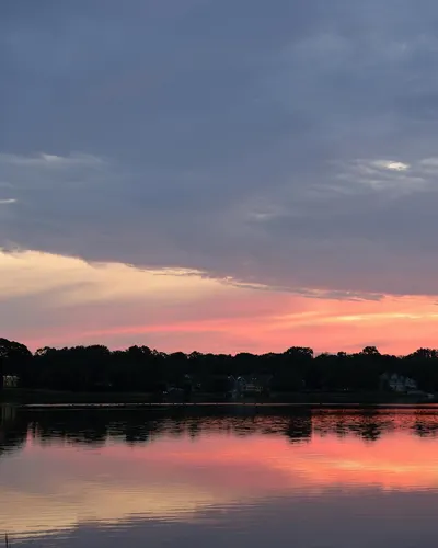 A tranquil sunset reflecting on a calm lake in Stamford, Connecticut, USA. 4k lake wallpaper