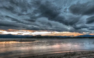 Captivating view of a dramatic cloudy sunset over a tranquil lake, reflecting vi 4k lake wallpaper