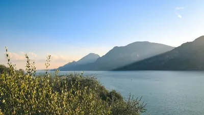 Sunset over Lake Garda with olive trees and mountain backdrop, Italy. 4k lake wallpaper