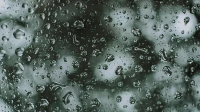 Artistic close-up photo capturing raindrops on a glass surface creating a textur 4k macro wallpaper