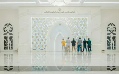 A beautiful and serene interior of a modern mosque with people praying in a mini 4k minimal wallpaper