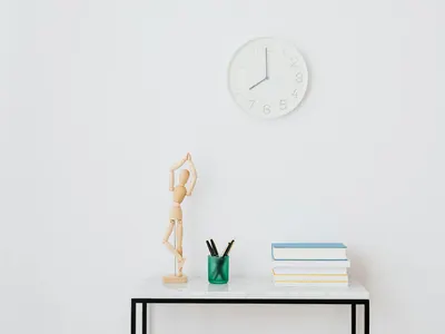 A minimalist workspace setup featuring books, a clock, and decorative elements o 4k minimal wallpaper
