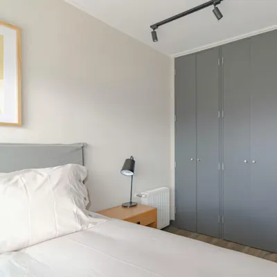 Contemporary bedroom featuring grey wardrobe and minimal decor, ideal for urban  4k minimal wallpaper
