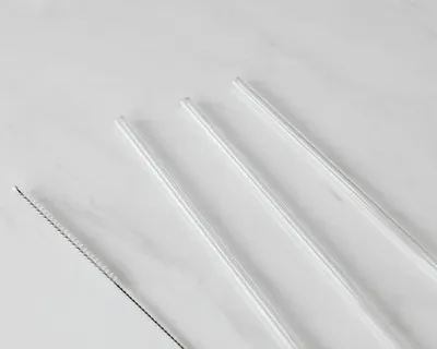 Minimalist image of three transparent glass straws and a cleaning brush on a whi 4k minimal wallpaper