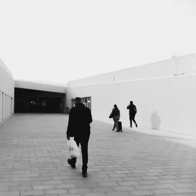 Monochrome minimalist urban scene with people walking past modern architecture i 4k minimal wallpaper