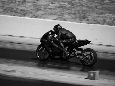 Black and white photograph capturing a motorcyclist in action during a high-spee 4k motorcycle wallpaper