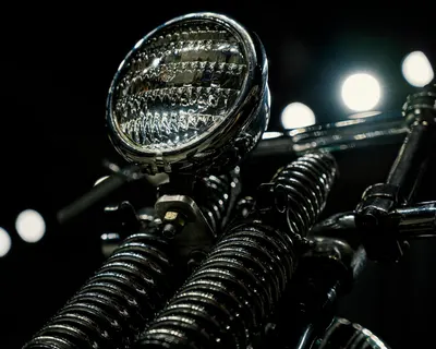 Close-up of a vintage motorcycle headlight with chrome detailing in low light. 4k motorcycle wallpaper