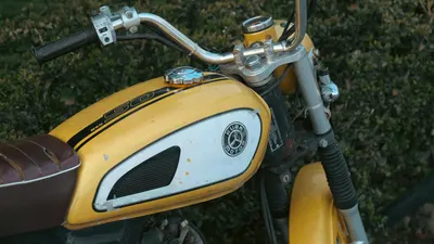 Close-up of a vintage yellow motorcycle tank, embodying retro vibes. 4k motorcycle wallpaper