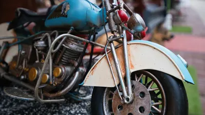 Detailed shot of a vintage blue and white toy motorcycle model displayed outdoor 4k motorcycle wallpaper