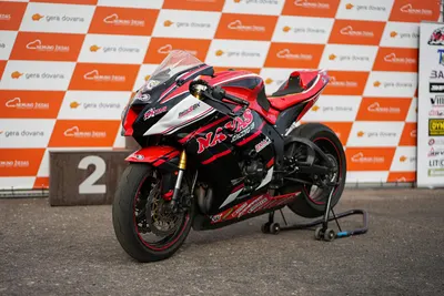 Red Kawasaki Ninja ZX-6R superbike parked at a motorsport podium event. 4k motorcycle wallpaper