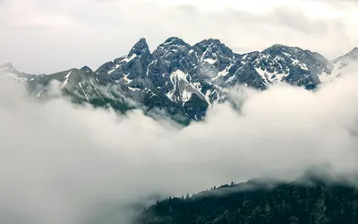Breathtaking view of snow-capped mountains and misty clouds in Oberstdorf, Germa 4k mountain wallpaper