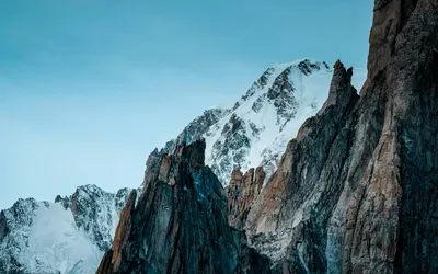 Breathtaking view of snow-capped peaks amidst a clear blue sky, capturing the se 4k mountain wallpaper