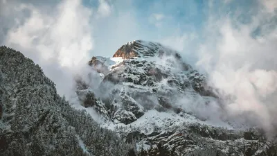 Majestic snowy peak surrounded by winter clouds in the Tyrolean Alps. 4k mountain wallpaper