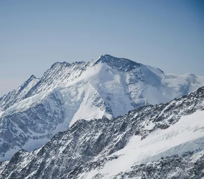 Stunning view of snow-covered Alps in Switzerland beneath a clear blue sky, capt 4k mountain wallpaper