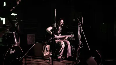 A female musician performing live with an electric guitar on stage. Concert atmo 4k music wallpaper