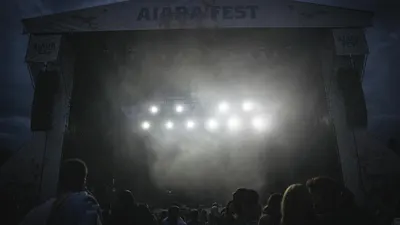 A misty night music festival scene with bright stage lights and a crowd of peopl 4k music wallpaper