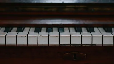 Close-up of vintage piano keys showcasing their antique and classic beauty. 4k music wallpaper