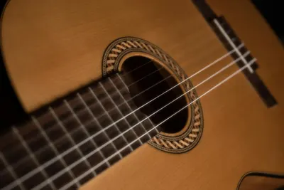 Detailed close-up of a classic acoustic guitar highlighting the strings and soun 4k music wallpaper