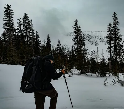 A hiker explores the snowy landscape of Karkonosze, Poland, during winter. 4k nature wallpaper