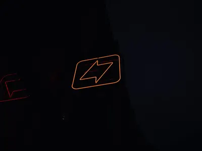 A glowing neon lightning bolt sign against a dark night background, symbolizing  4k neon wallpaper