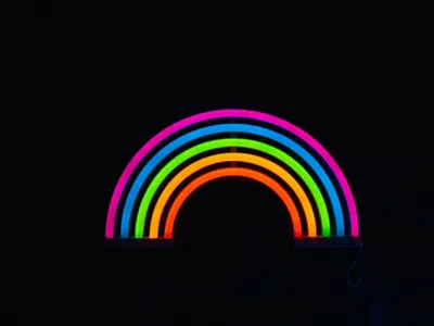 A glowing neon rainbow against a dark background, showcasing colorful LED lights 4k neon wallpaper