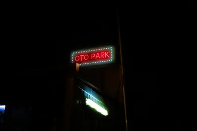 A vibrant neon sign reading 'Oto Park' glowing in the night sky, surrounded by d 4k neon wallpaper