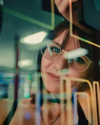 A woman reflected in arcade machine glass, enveloped in neon lights. 4k neon wallpaper