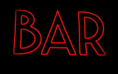Bright red neon bar sign glowing against a dark backdrop. 4k neon wallpaper