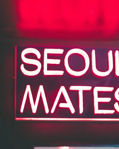 Vibrant pink neon sign reading 'Seoul Mates' glowing in the dark. Perfect for ni 4k neon wallpaper