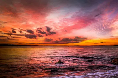 A breathtaking sunset over a tranquil ocean, with vibrant colors and serene atmo 4k sunset wallpaper