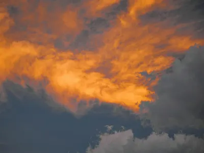 A striking image of vivid orange clouds during sunset against a dramatic sky. 4k sunset wallpaper