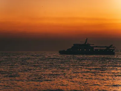 A tranquil sunset over İstanbul's coast, highlighting a silhouetted ship against 4k sunset wallpaper